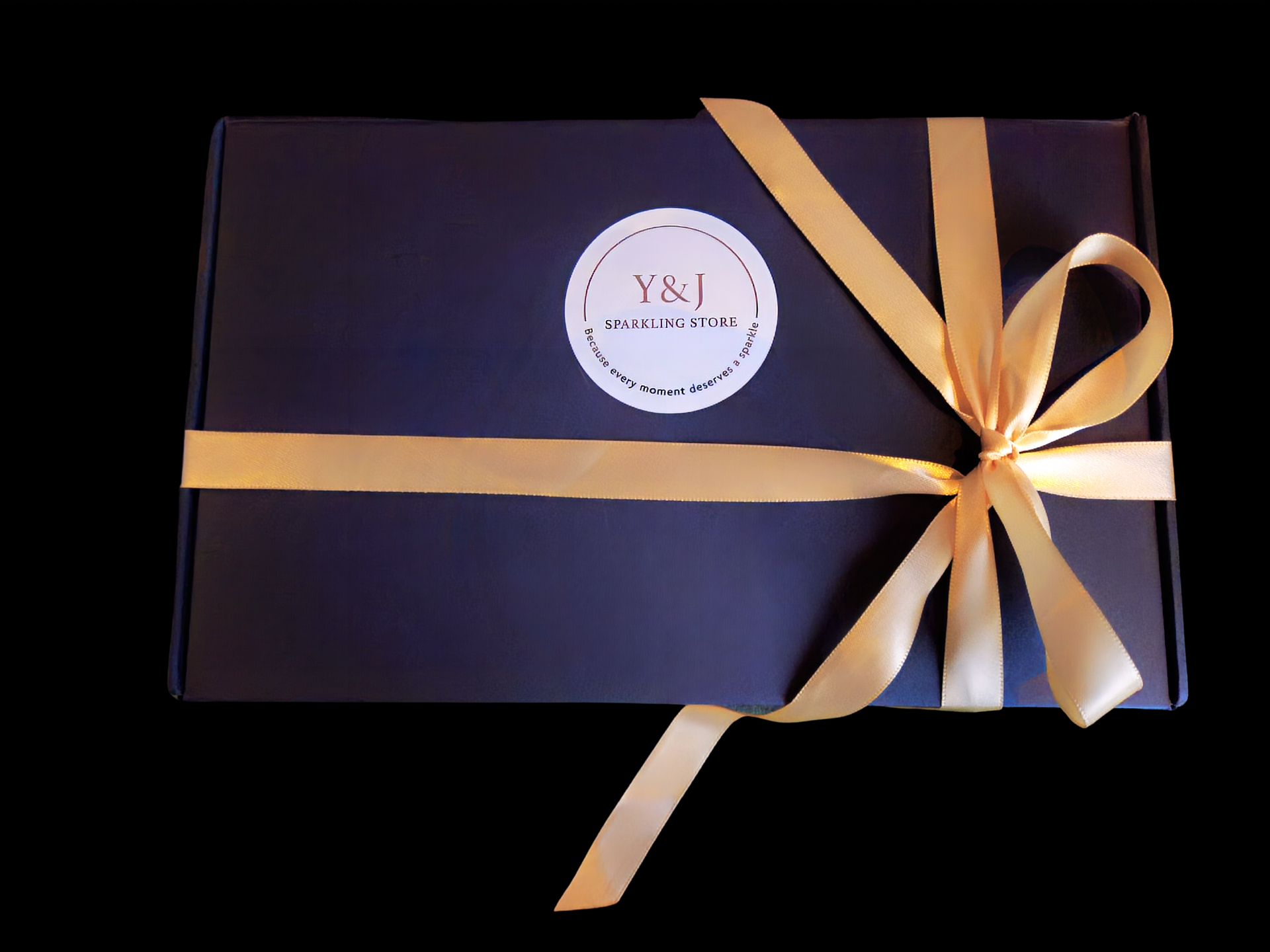 Een donkerblauwe geschenkdoos, vastgebonden met een gouden lint en voorzien van een ronde witte sticker met de tekst 
