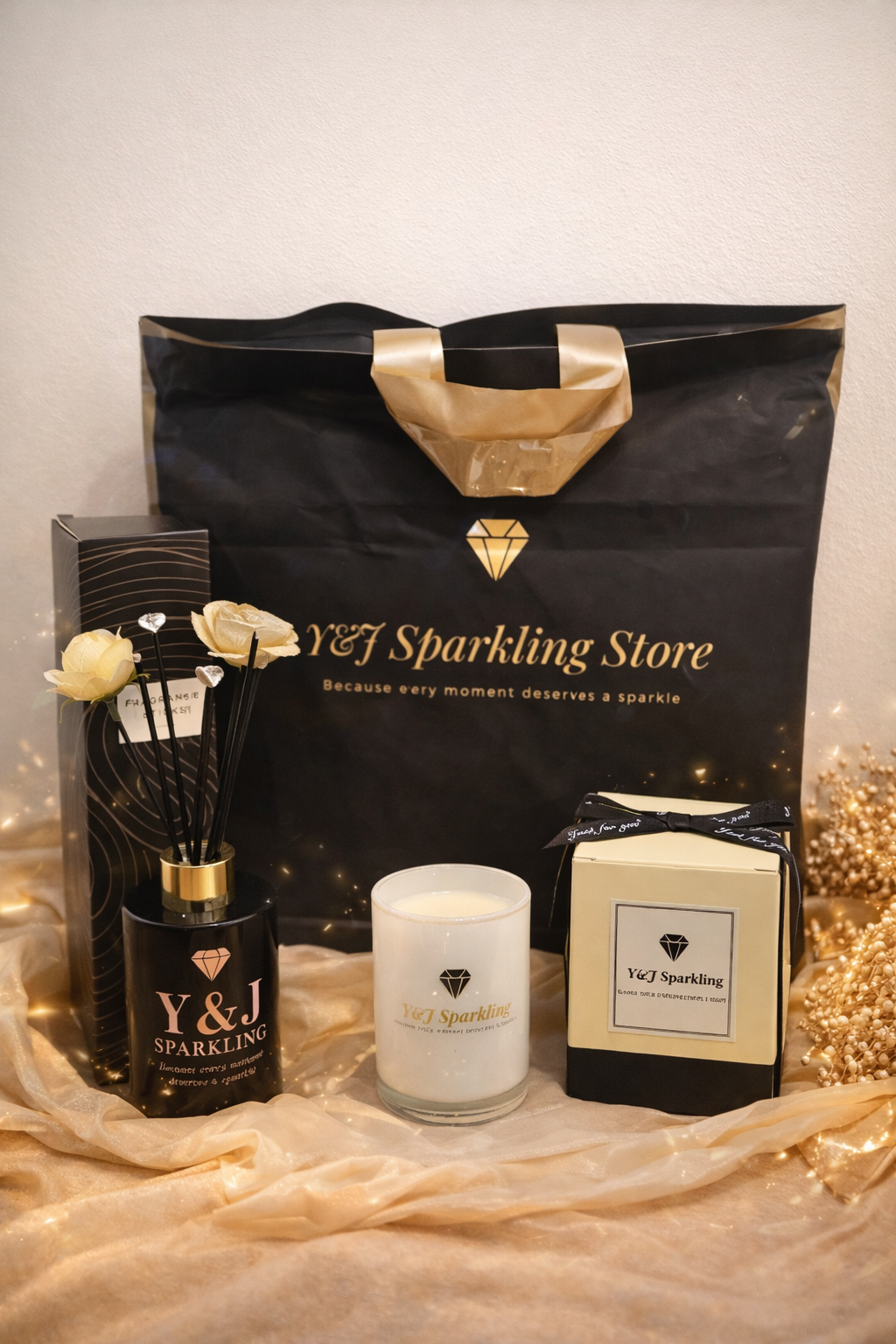 Cadeauset met producten van Y&J Sparkling Store: aromadiffuser, kaars en cadeautasje op een gouden doek.