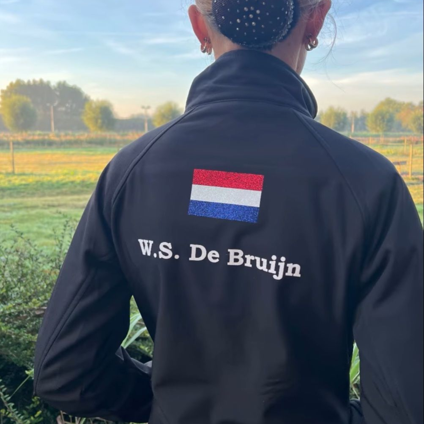 Vrouw met zwarte jas met Nederlandse vlag en