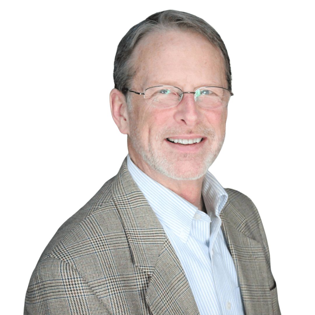 A man wearing glasses and a suit is smiling for the camera.