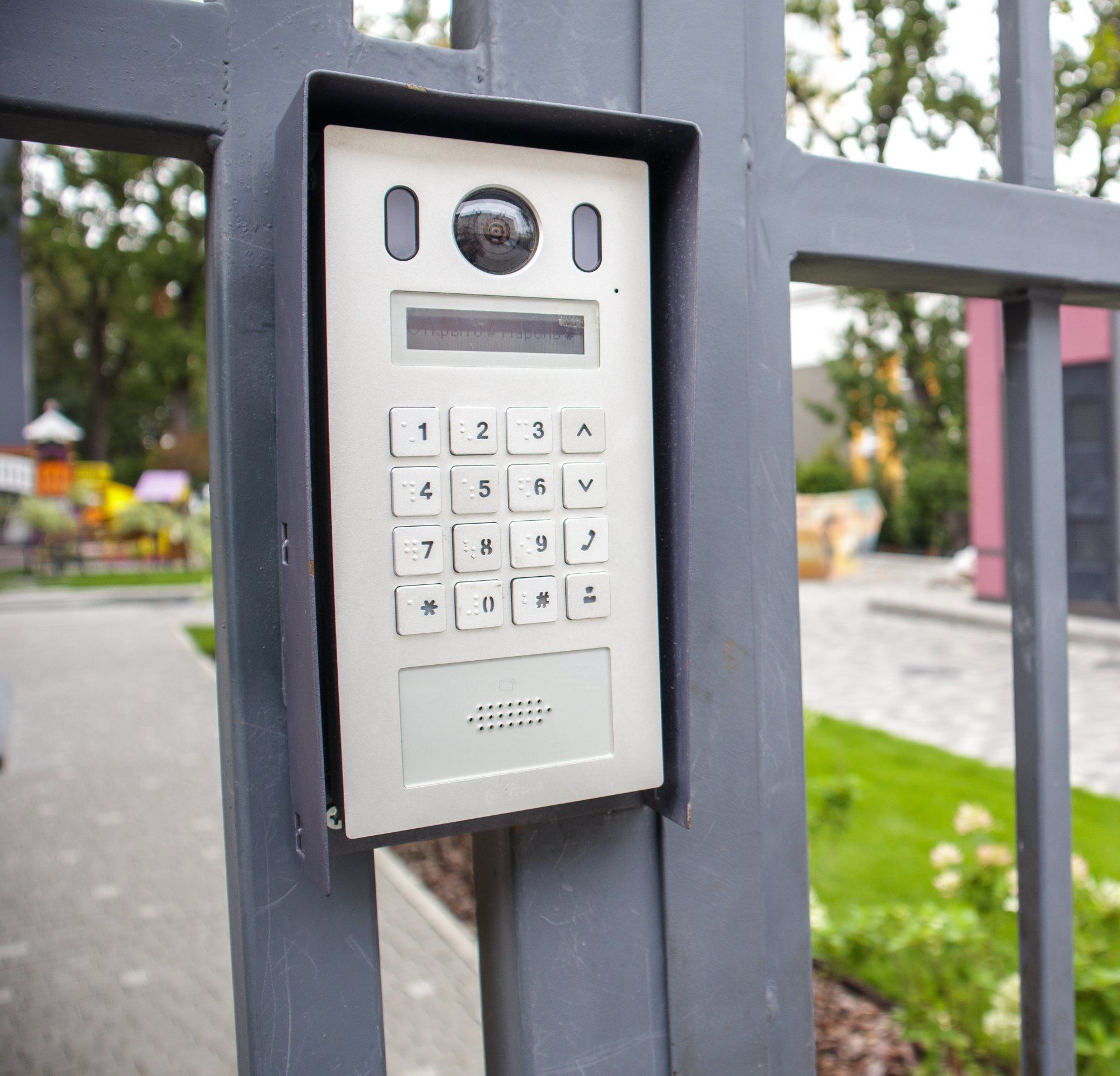 A keypad is attached to the side of a fence.