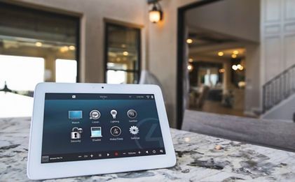 A tablet is sitting on a counter in front of a house.