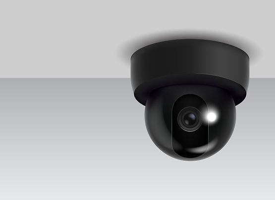 A black security camera is hanging from the ceiling.