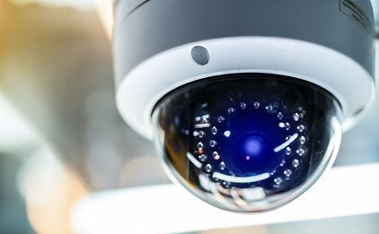 A close up of a security camera with a blue light coming out of it.