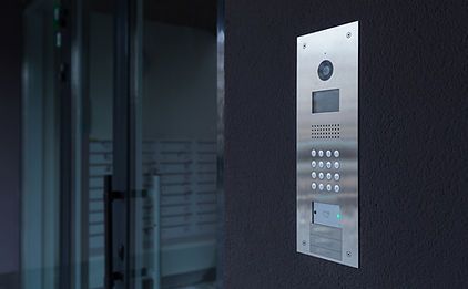 There is a doorbell on the wall next to a door.