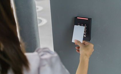 A woman is using a rfid card to open a door.