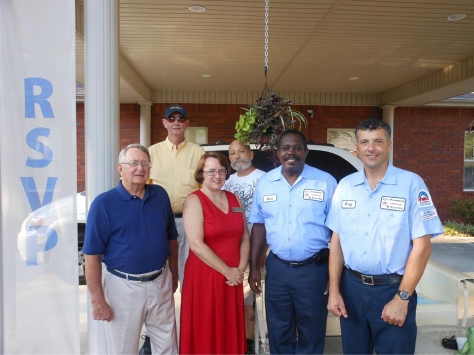 A group of people standing in front of a sign that says rsvp