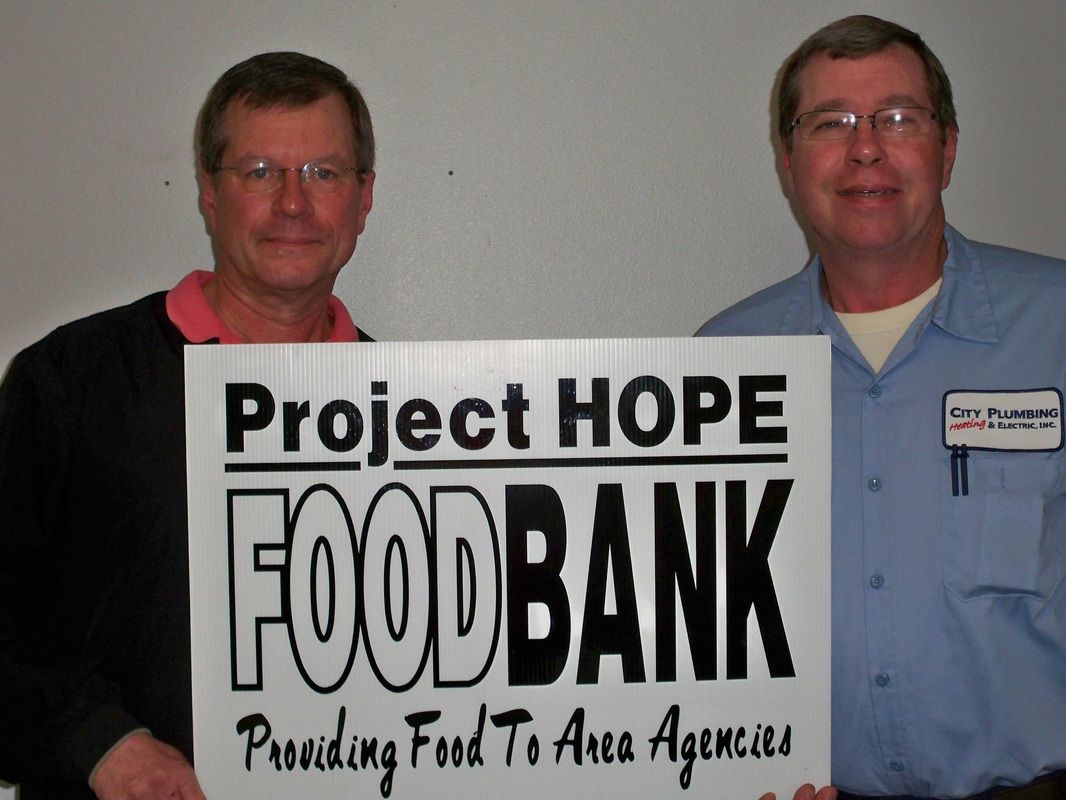 Two men holding a sign that says project hope foodbank