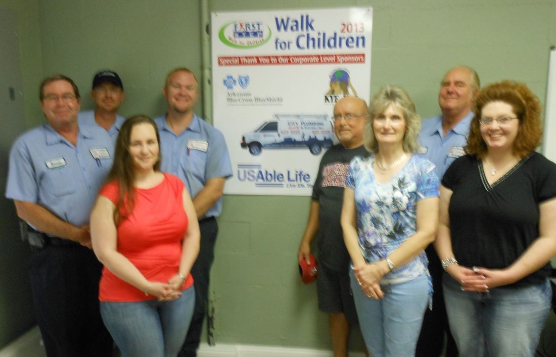 A group of people standing in front of a sign that says walk for children