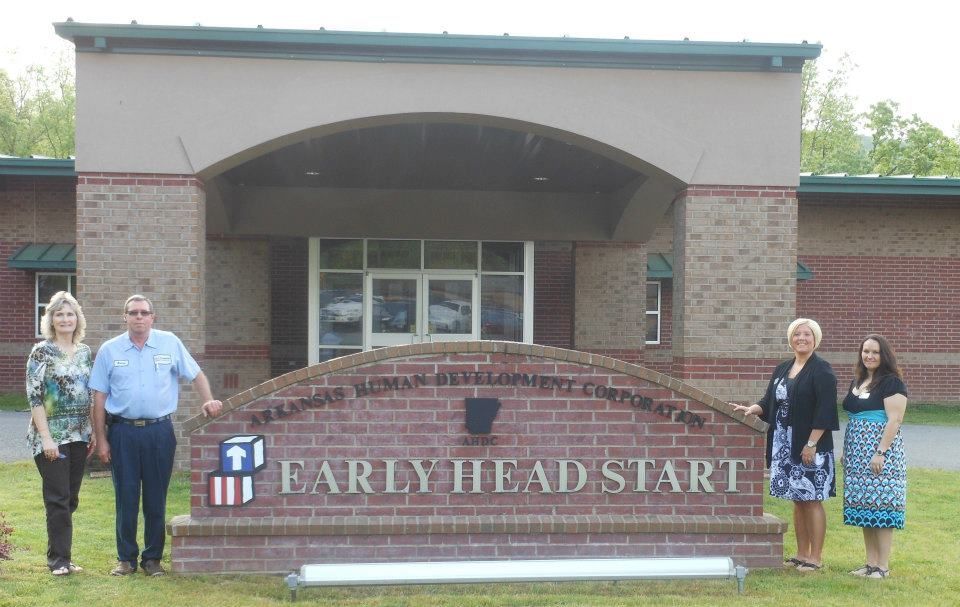 A group of people standing in front of an early head start building.