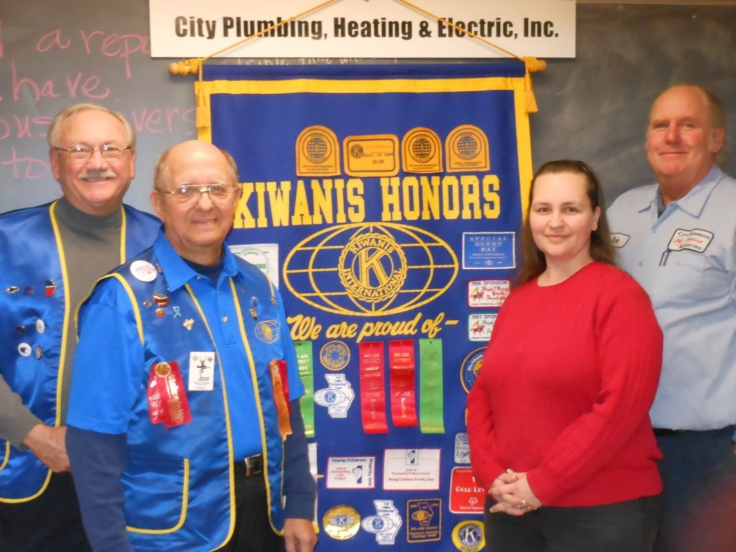 A group of people standing in front of a sign that says kiwanis honors