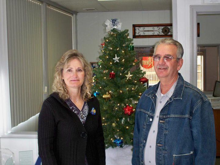 A man and a woman standing in front of a christmas tree