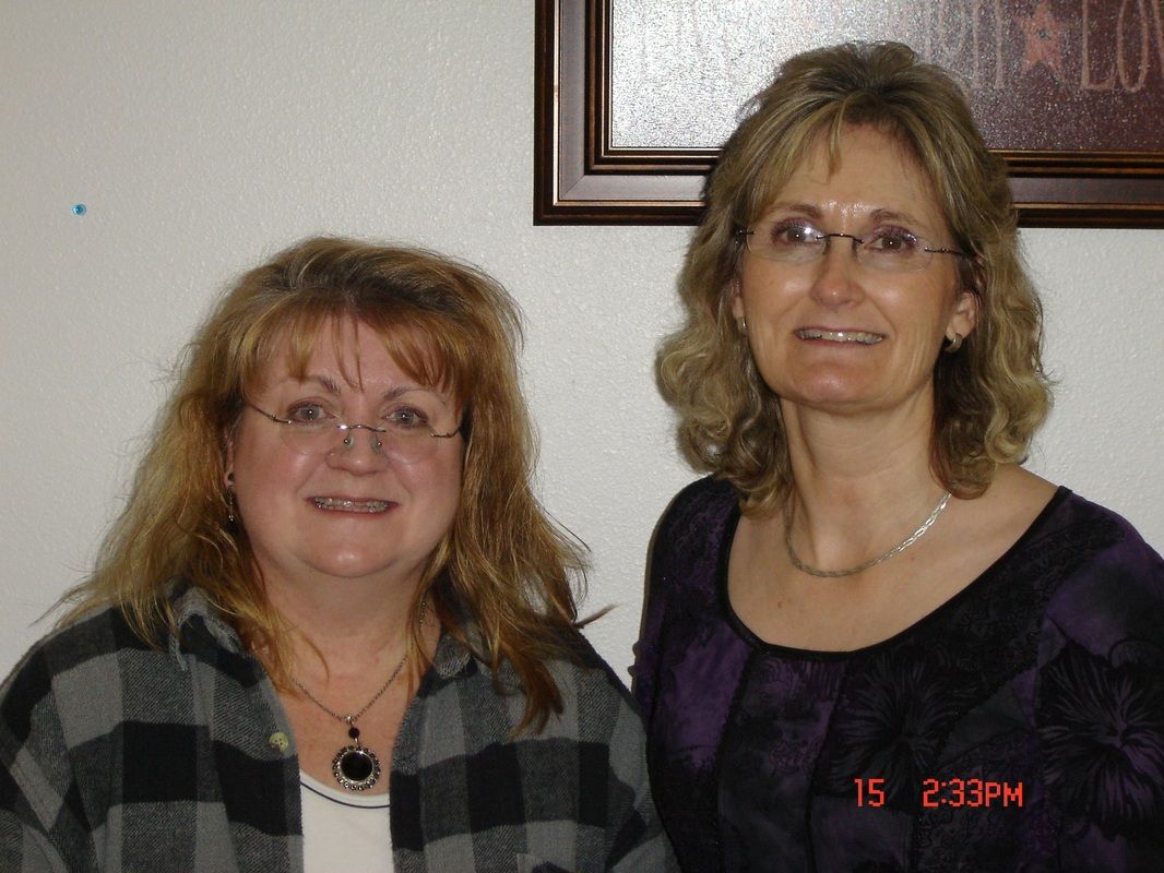 Two women are standing next to each other and smiling for the camera.