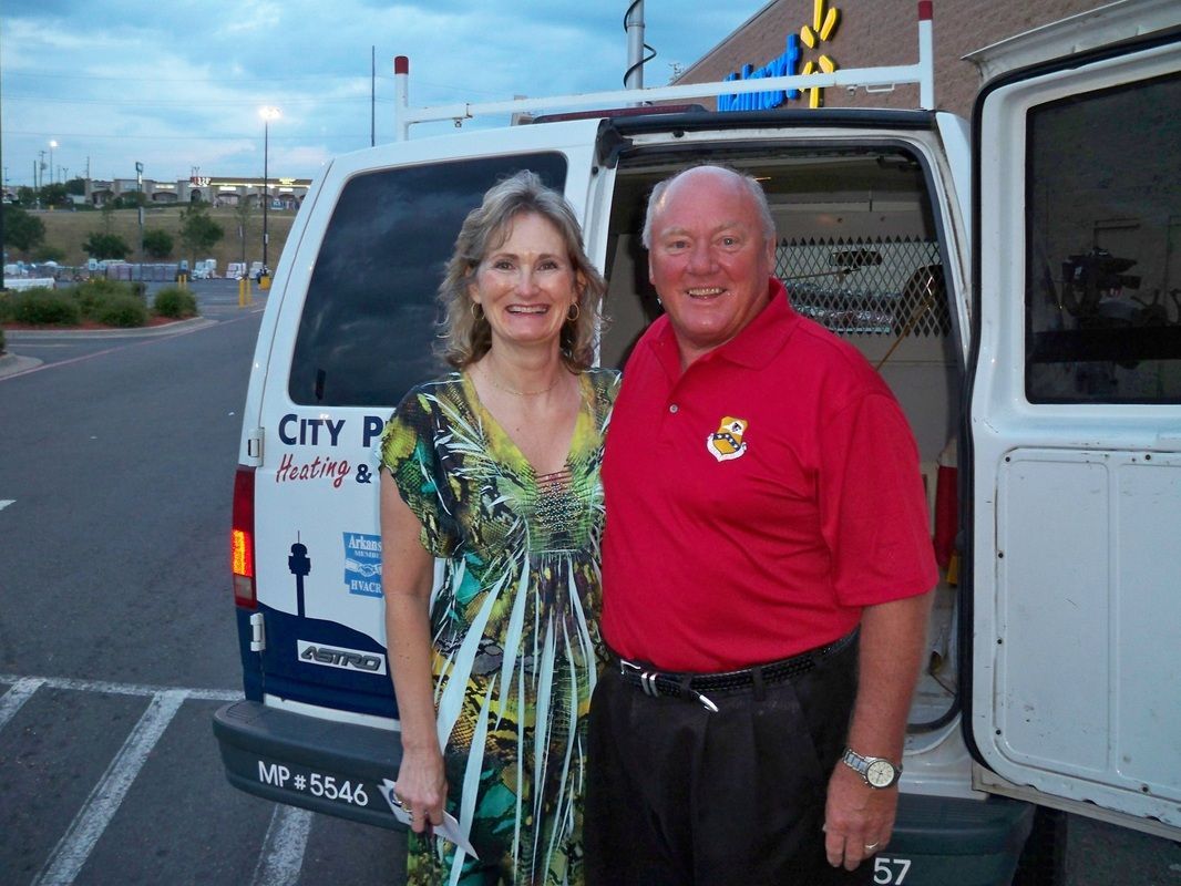 A man and woman standing in front of a van that says city