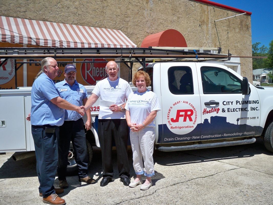 A group of people standing in front of a truck that says city plumbing