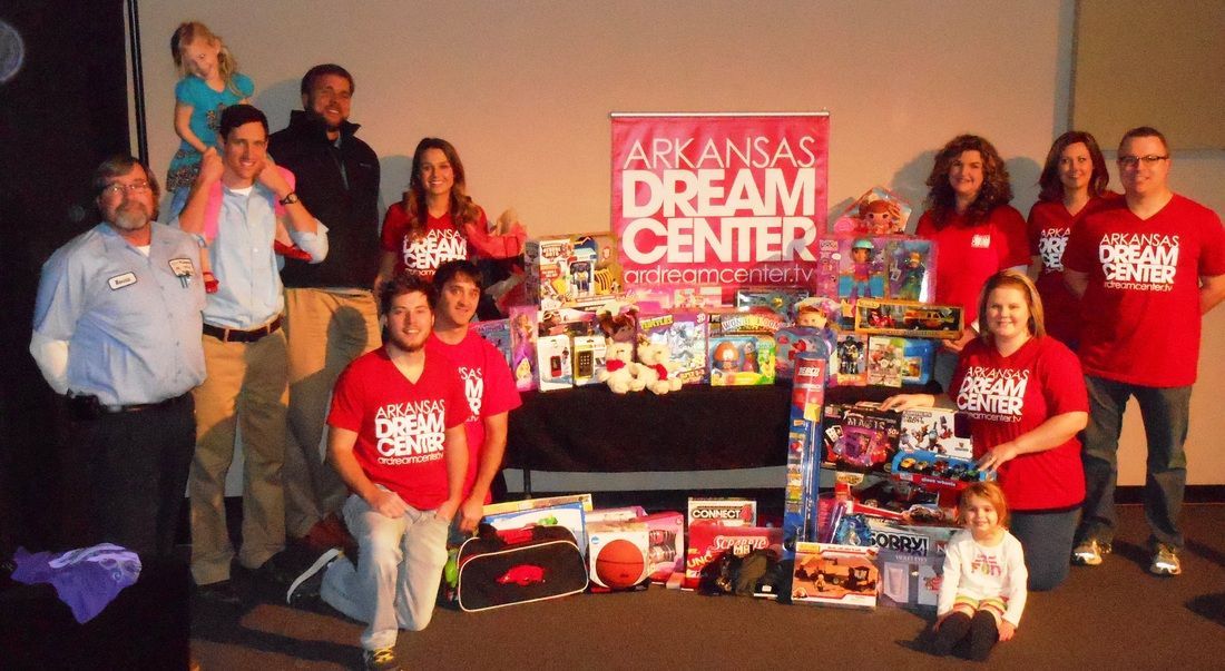 A group of people standing in front of a sign that says arkansas dream center