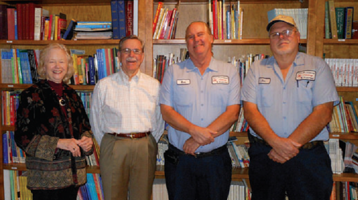 A group of people standing in front of a bookshelf