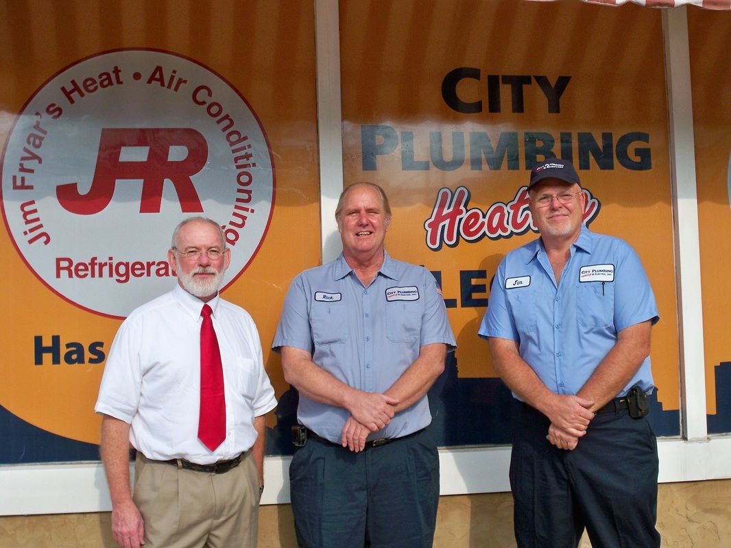 Three men standing in front of a city plumbing sign