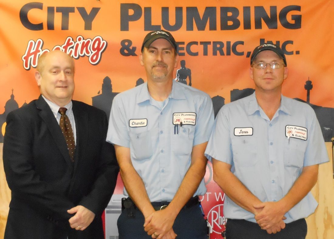 Three men standing in front of a city plumbing sign