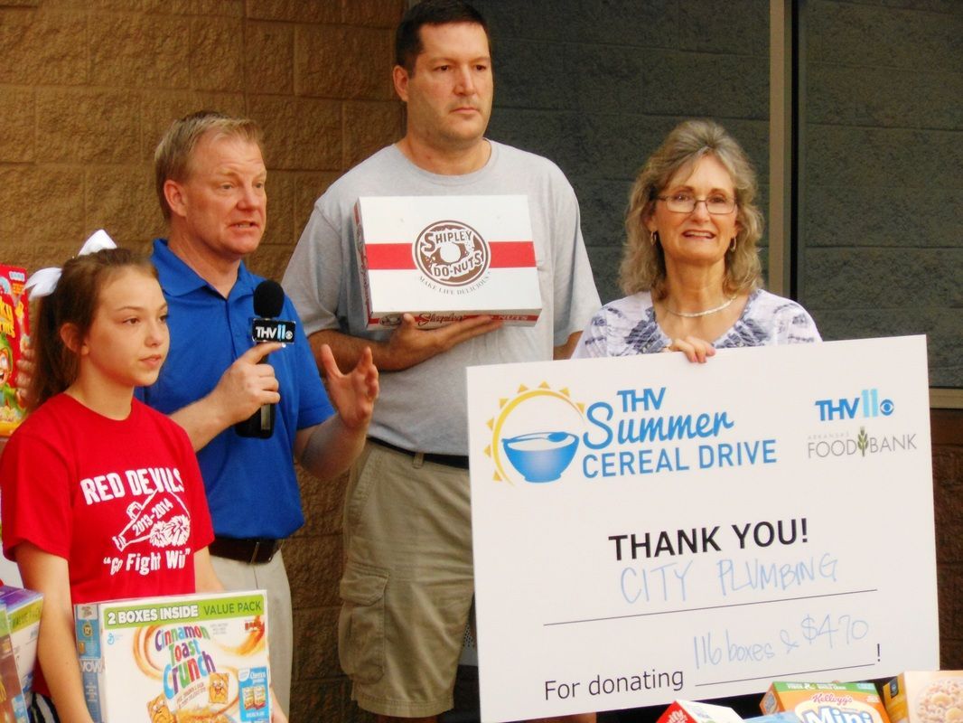 A group of people holding a sign that says the summer cereal drive