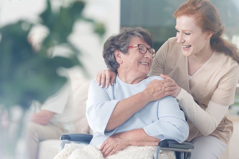 Nurse comforting and supporting senior woman