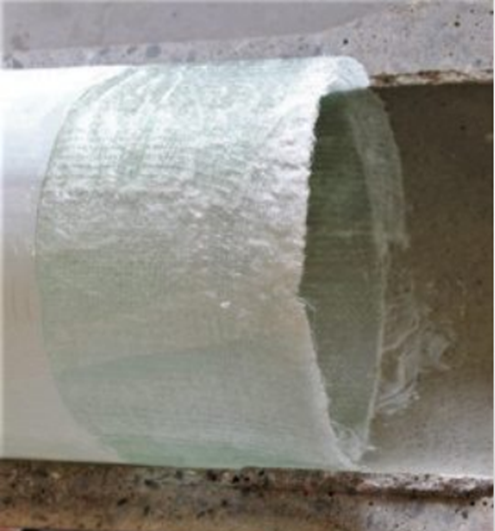 A bottle of liquid is being poured into a pipe.