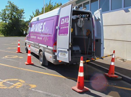 A purple van is parked in a parking lot