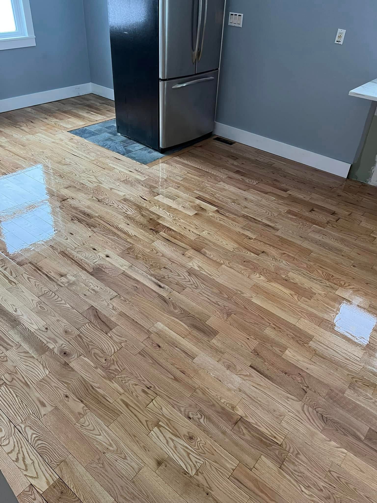 A kitchen with hardwood floors and a refrigerator.