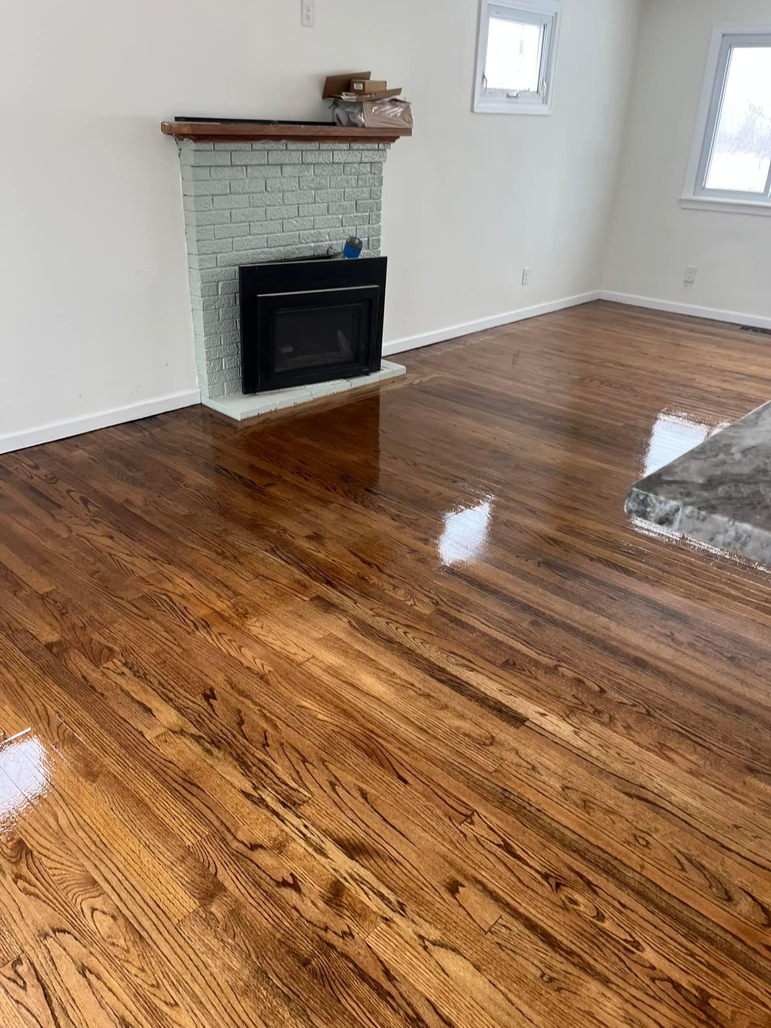 A living room with hardwood floors and a fireplace.