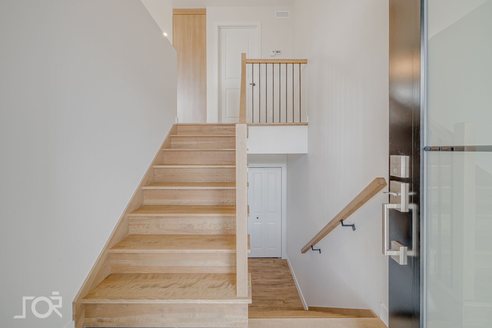 Une pièce vide avec du parquet et des murs blancs.