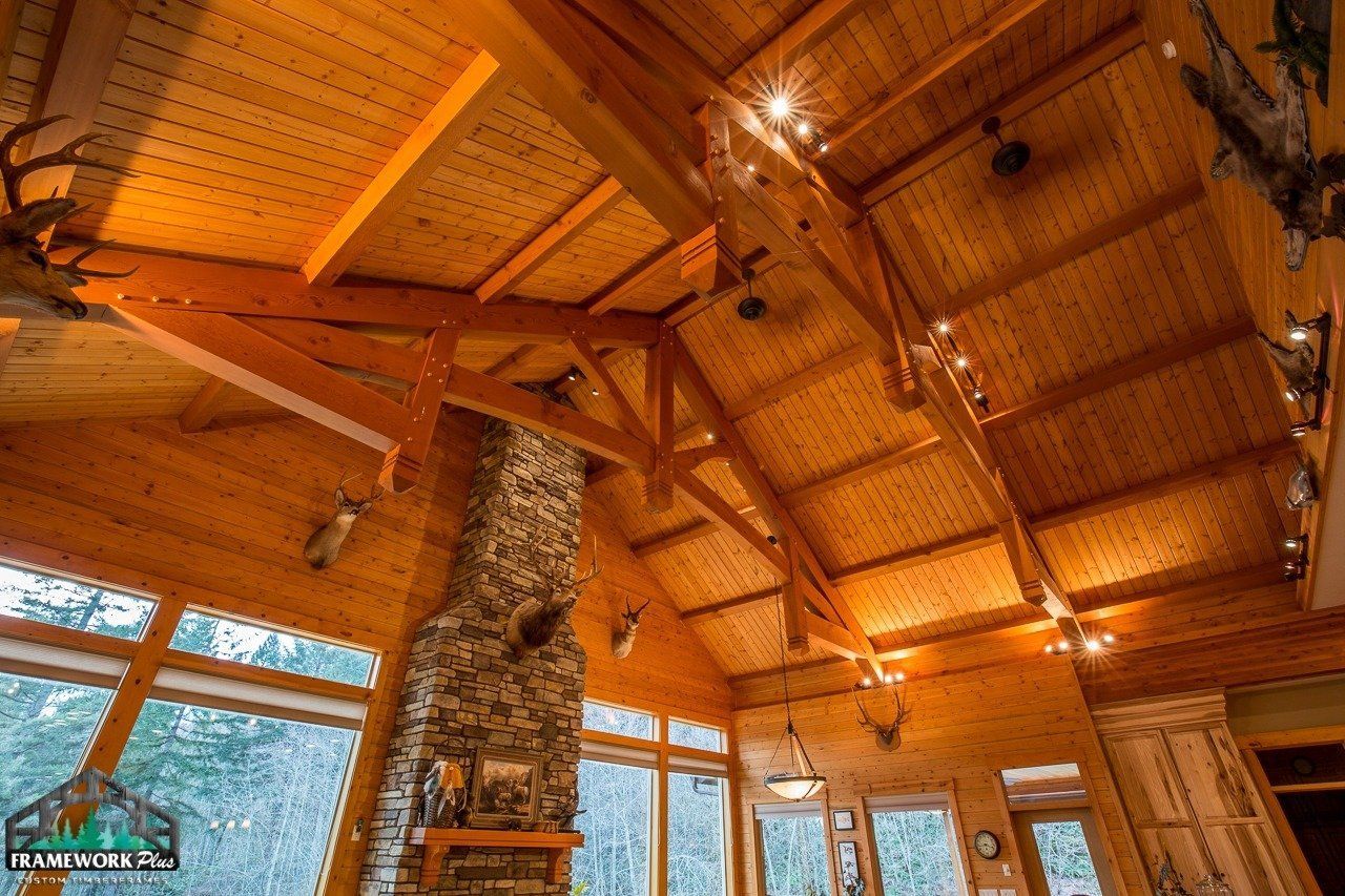 A large wooden house with a vaulted ceiling and a fireplace.