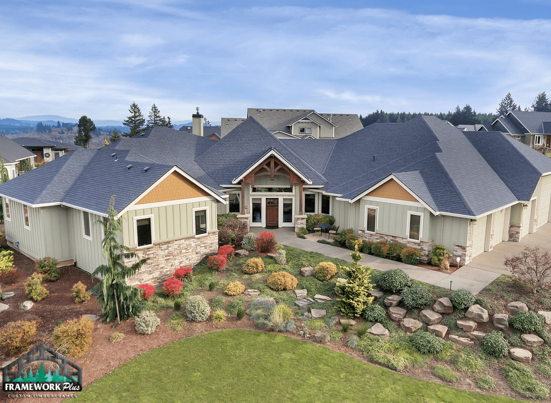 A large white house with a blue roof is sitting on top of a hill.