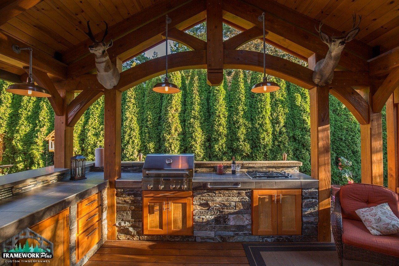 A kitchen under a wooden roof with deer heads on the ceiling.