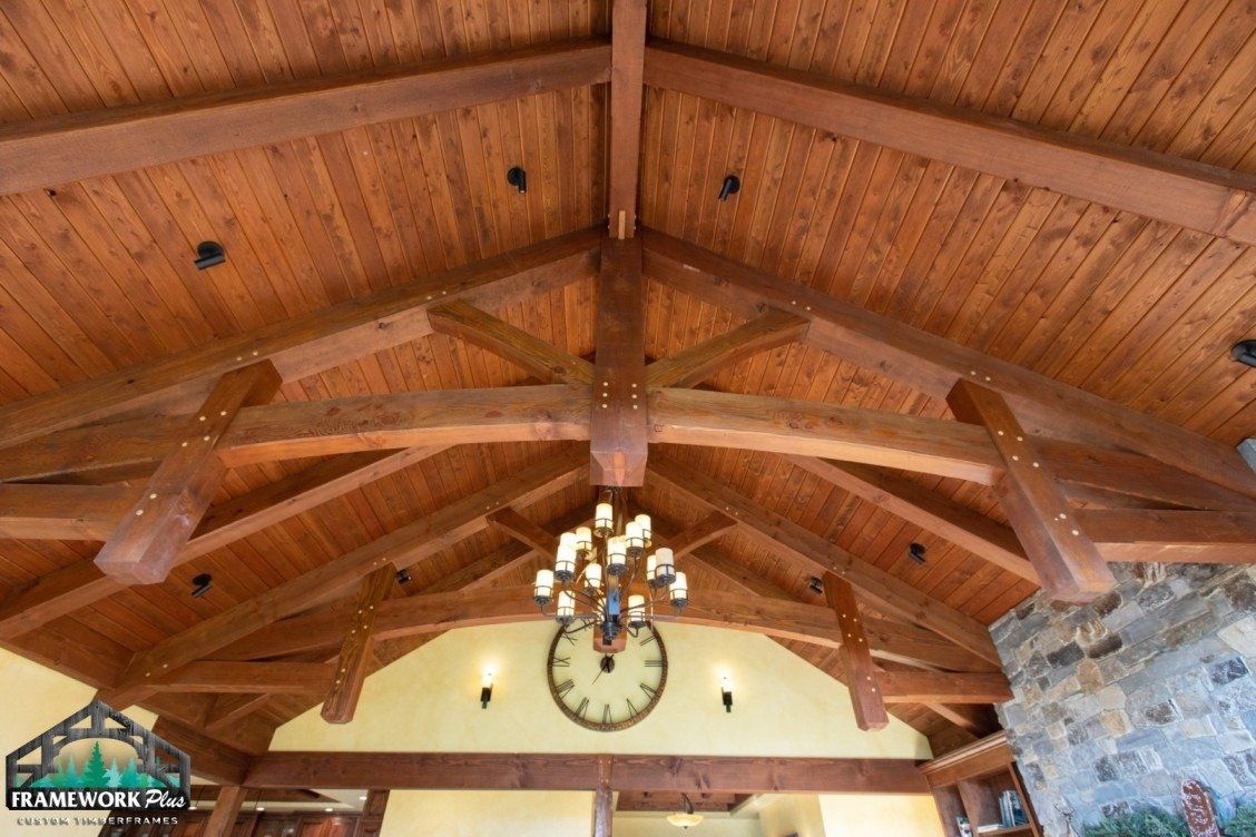 A wooden ceiling with a clock hanging from it