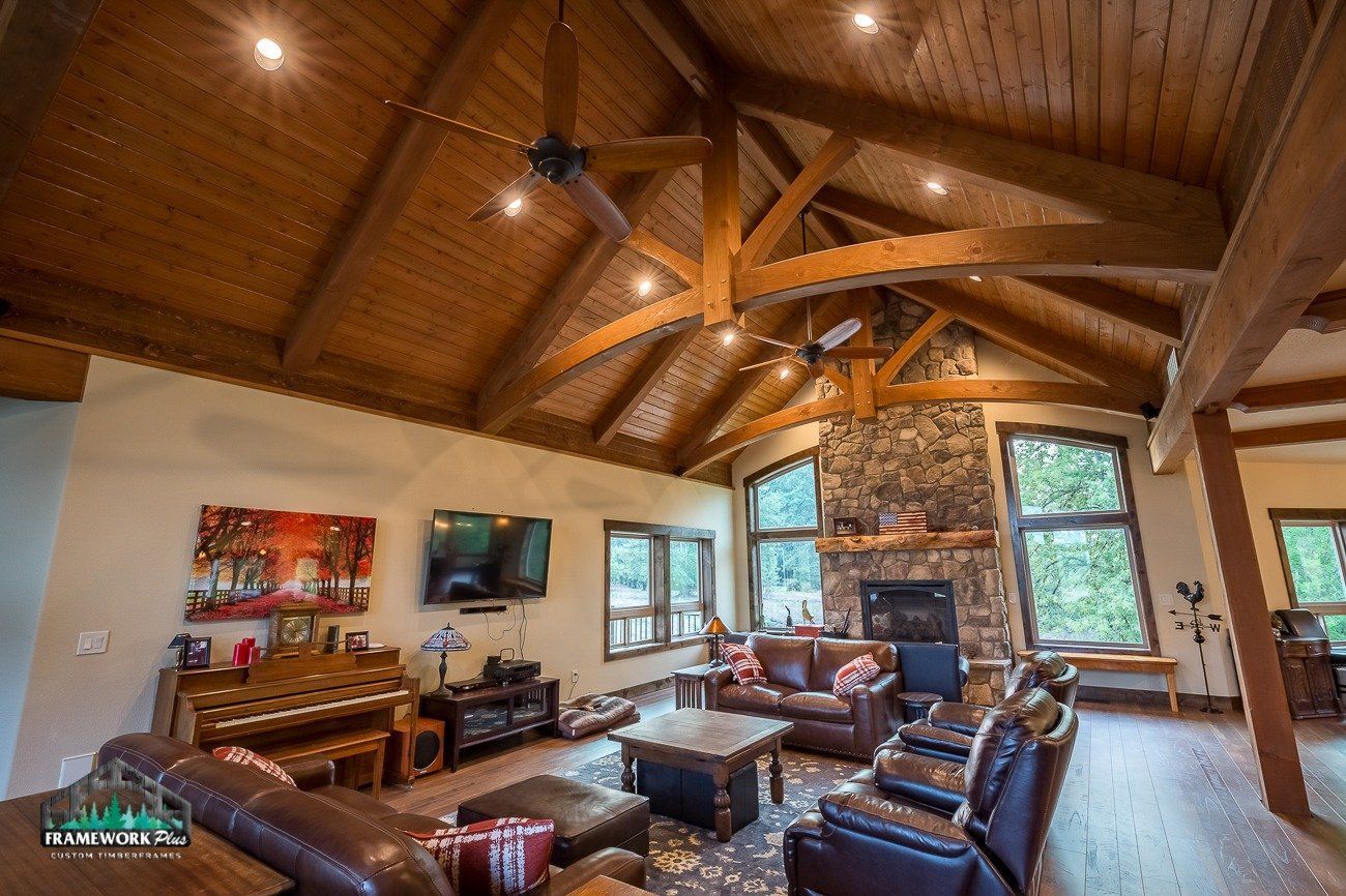 A living room with a wooden ceiling and a fireplace.