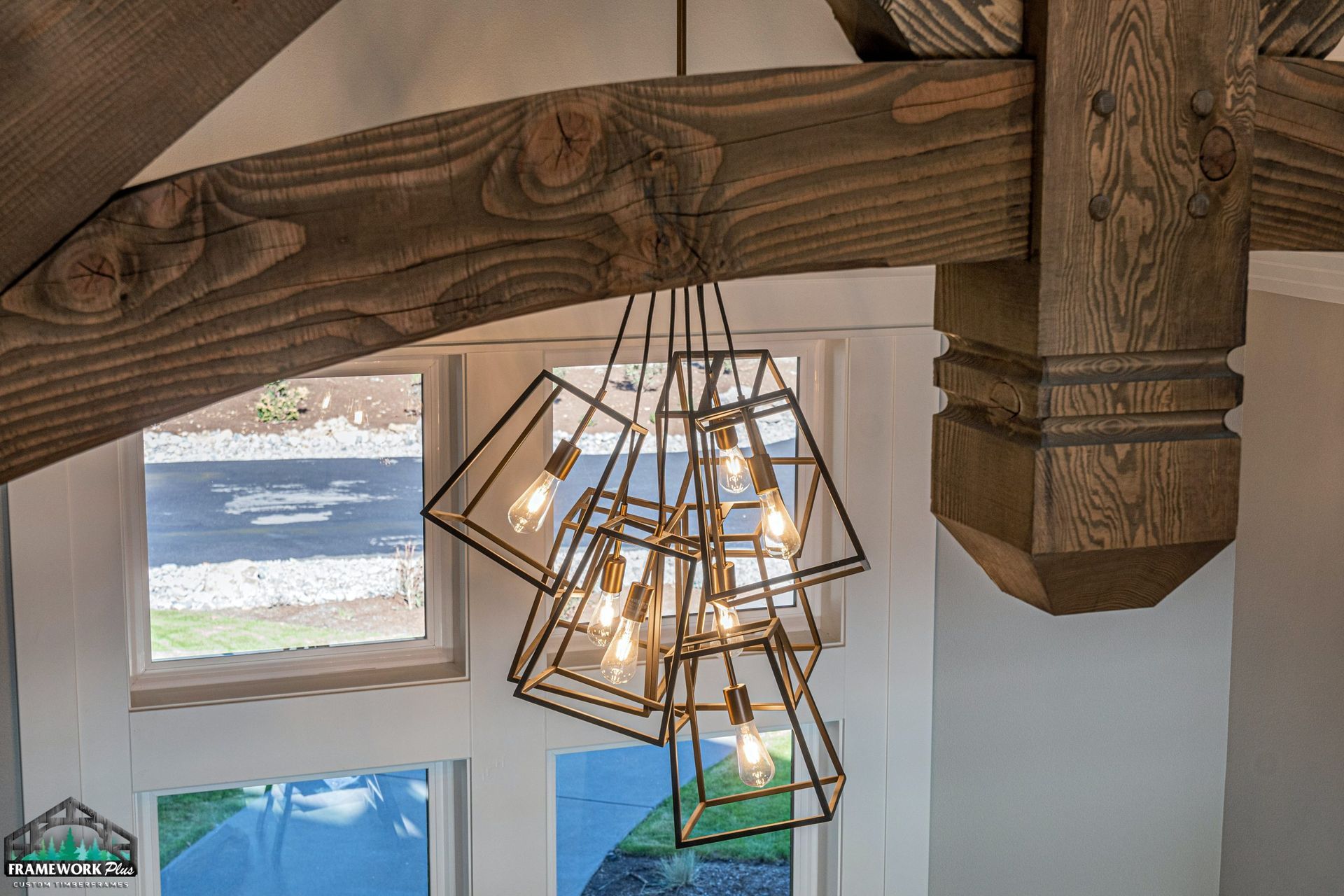 A chandelier is hanging from the ceiling in a room with wooden beams.
