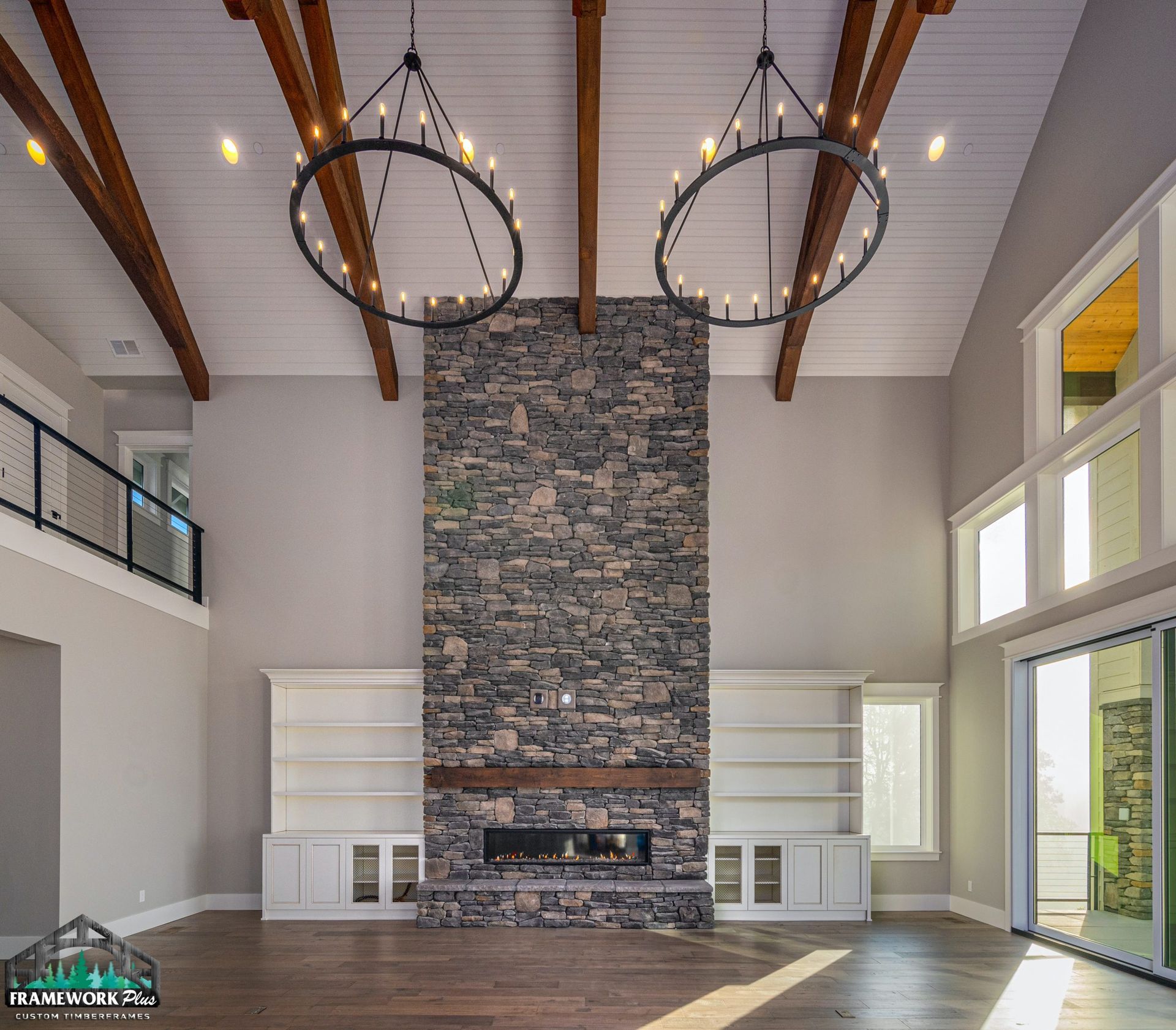 There is a large stone fireplace in the middle of the room.