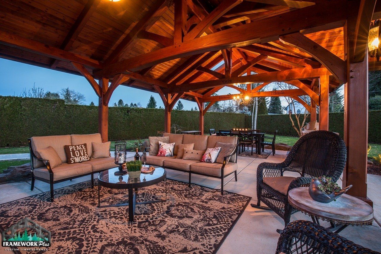 A gazebo with a couch , table , chairs and a rug.