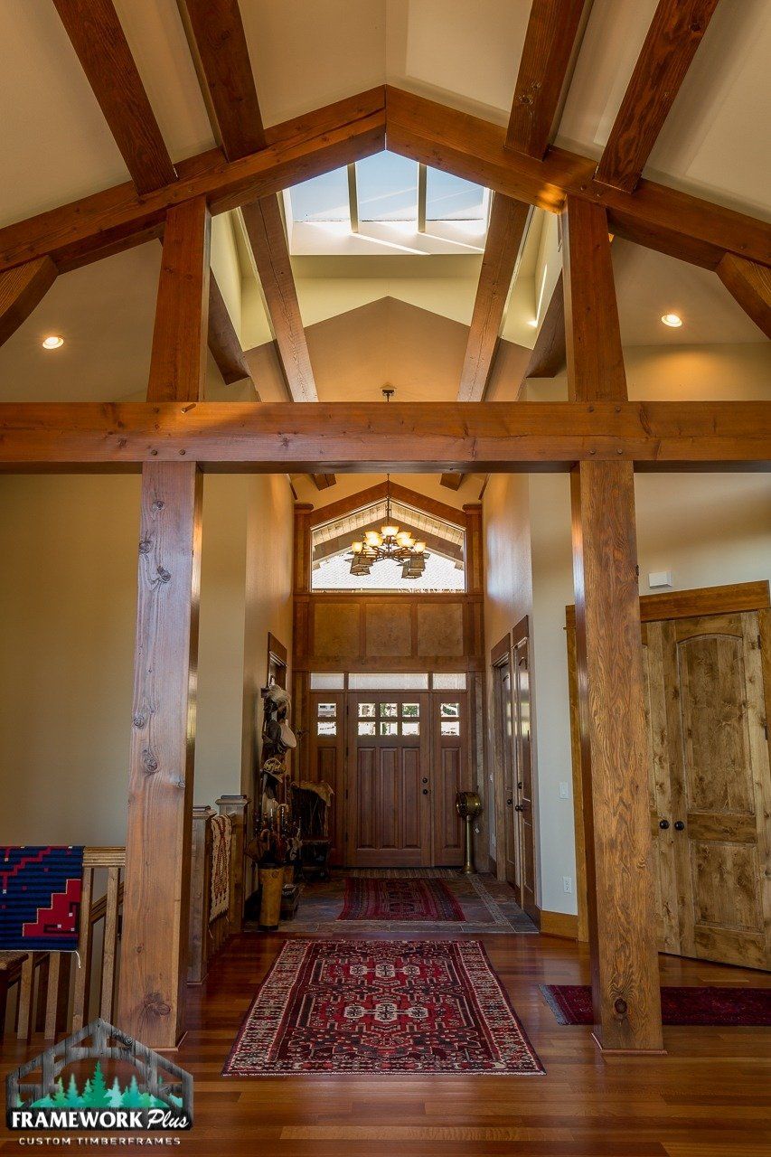 A hallway in a house with wooden beams and a rug.