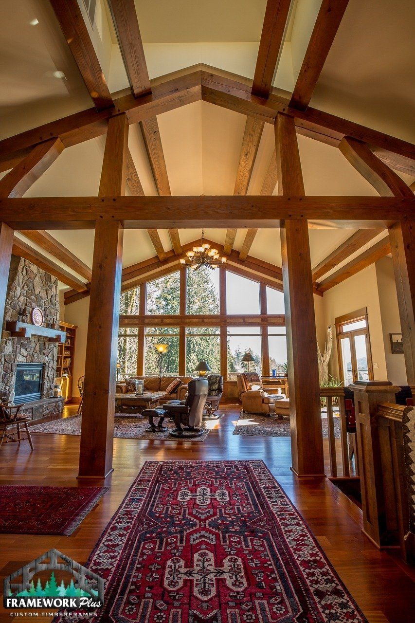 A large living room with a wooden ceiling and a rug.