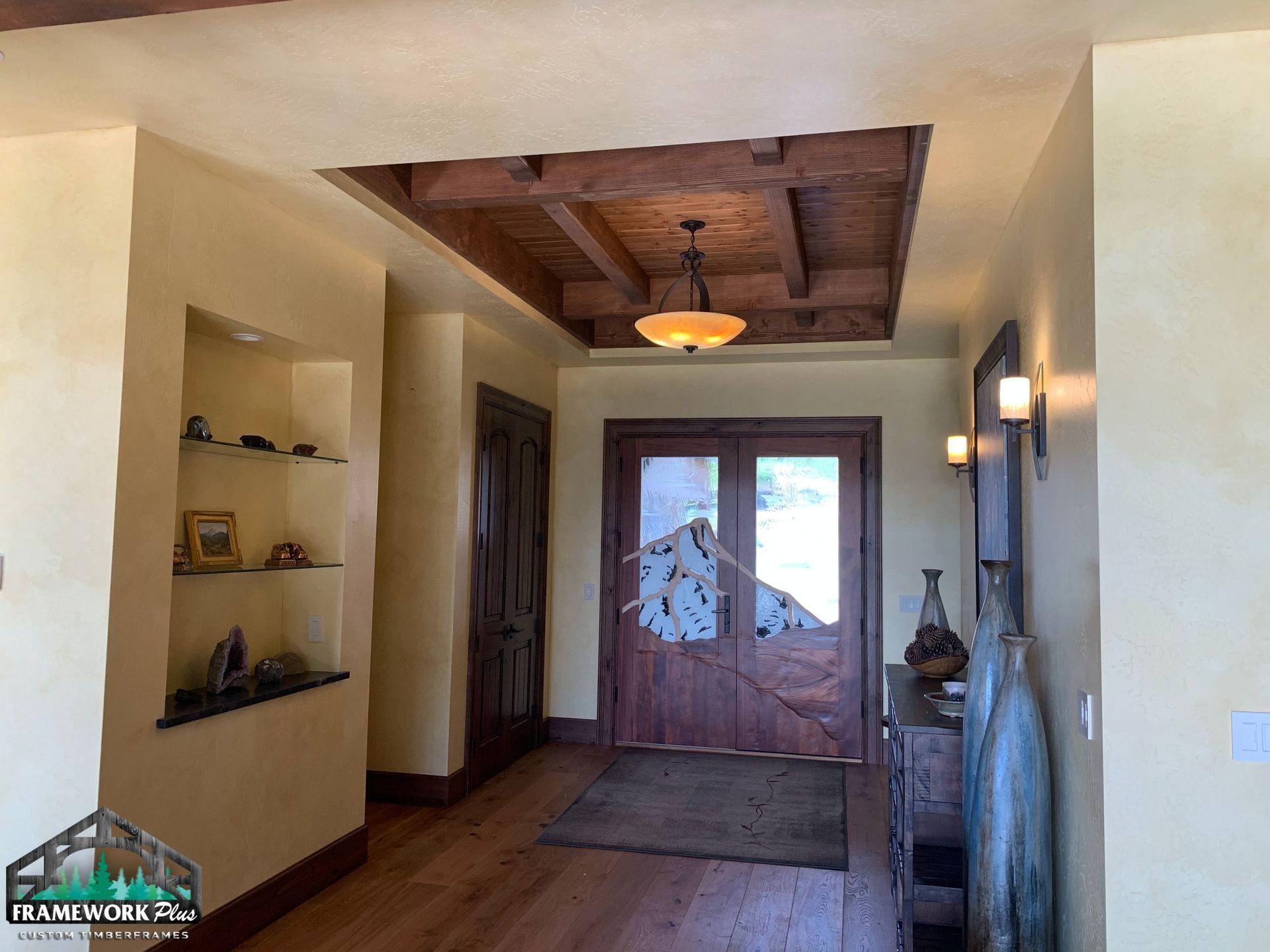 A hallway with a wooden door and a ceiling light