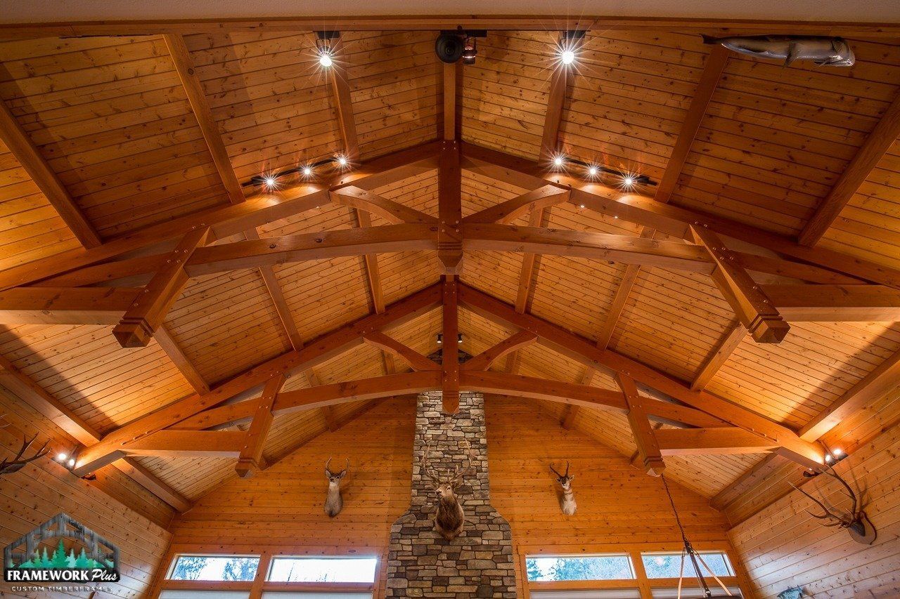 A large room with a wooden ceiling and a stone fireplace.