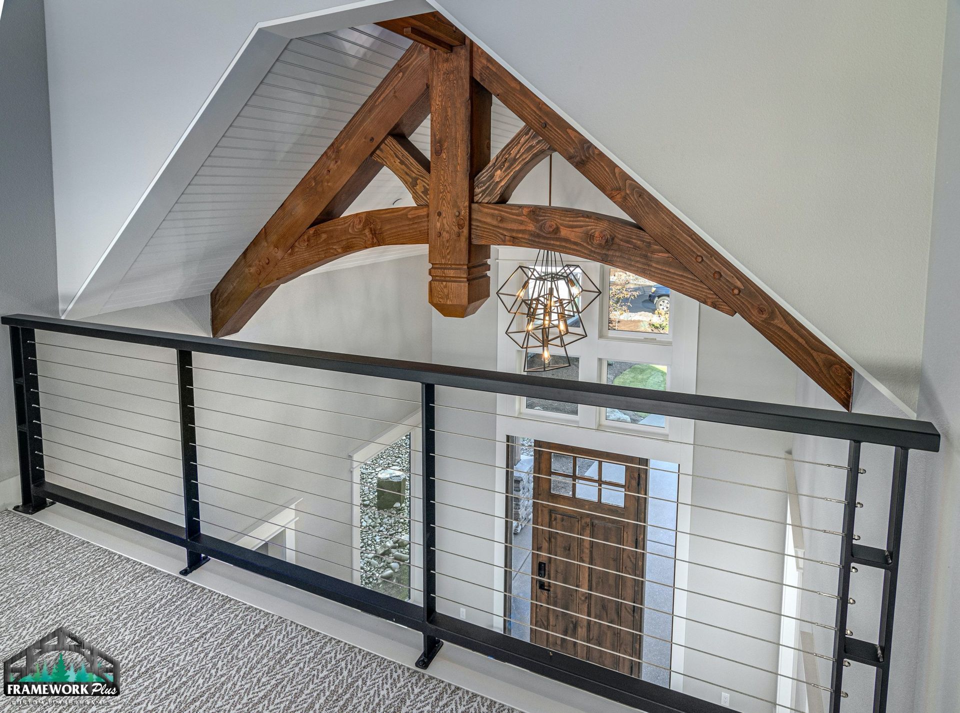A balcony in a house with a wooden ceiling and a metal railing