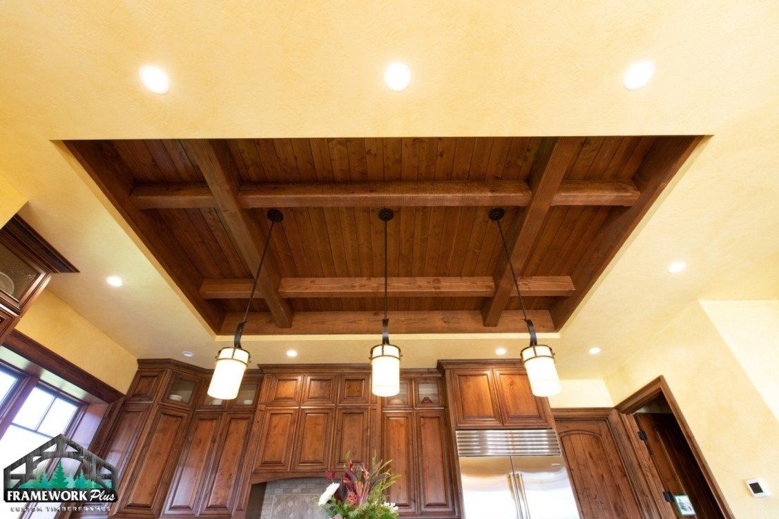 A kitchen with wooden cabinets and a wooden ceiling