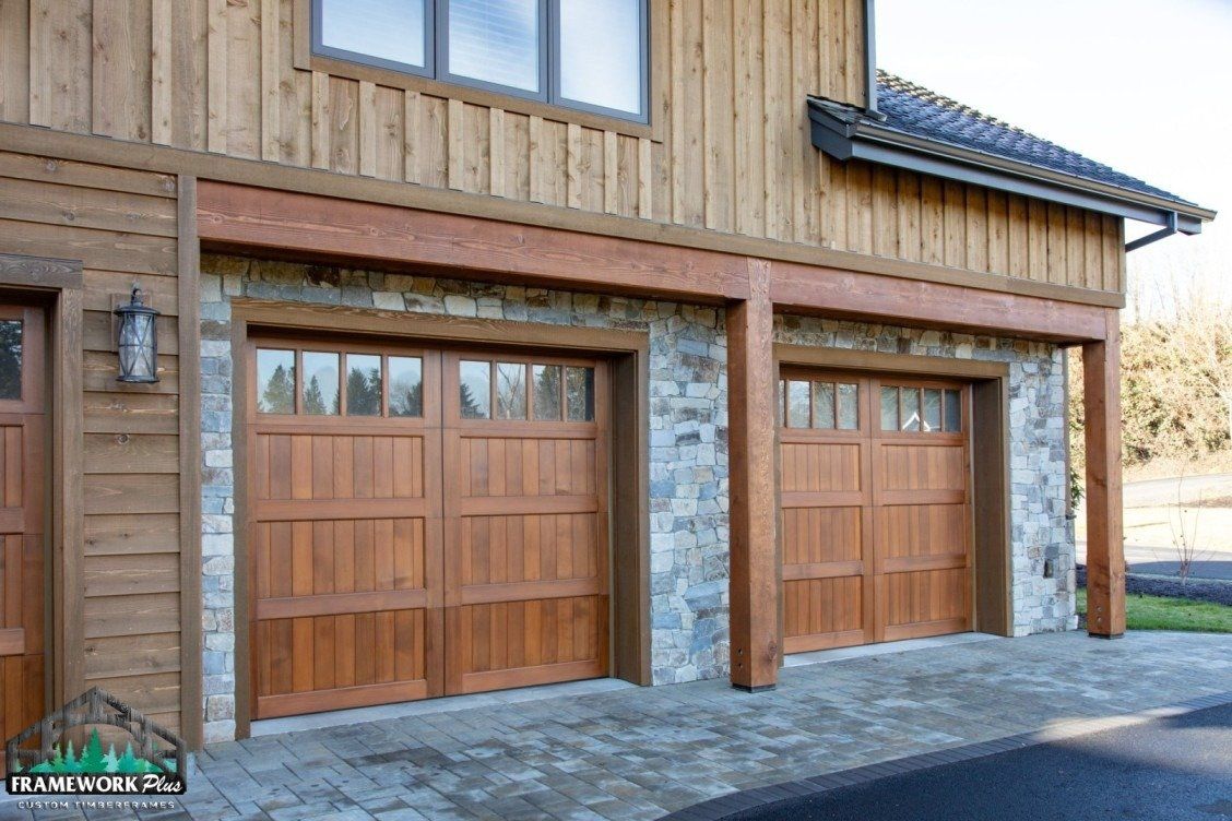 Two wooden garage doors on the side of a house