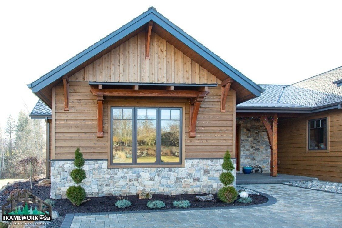 A small house with a wooden siding and a stone wall