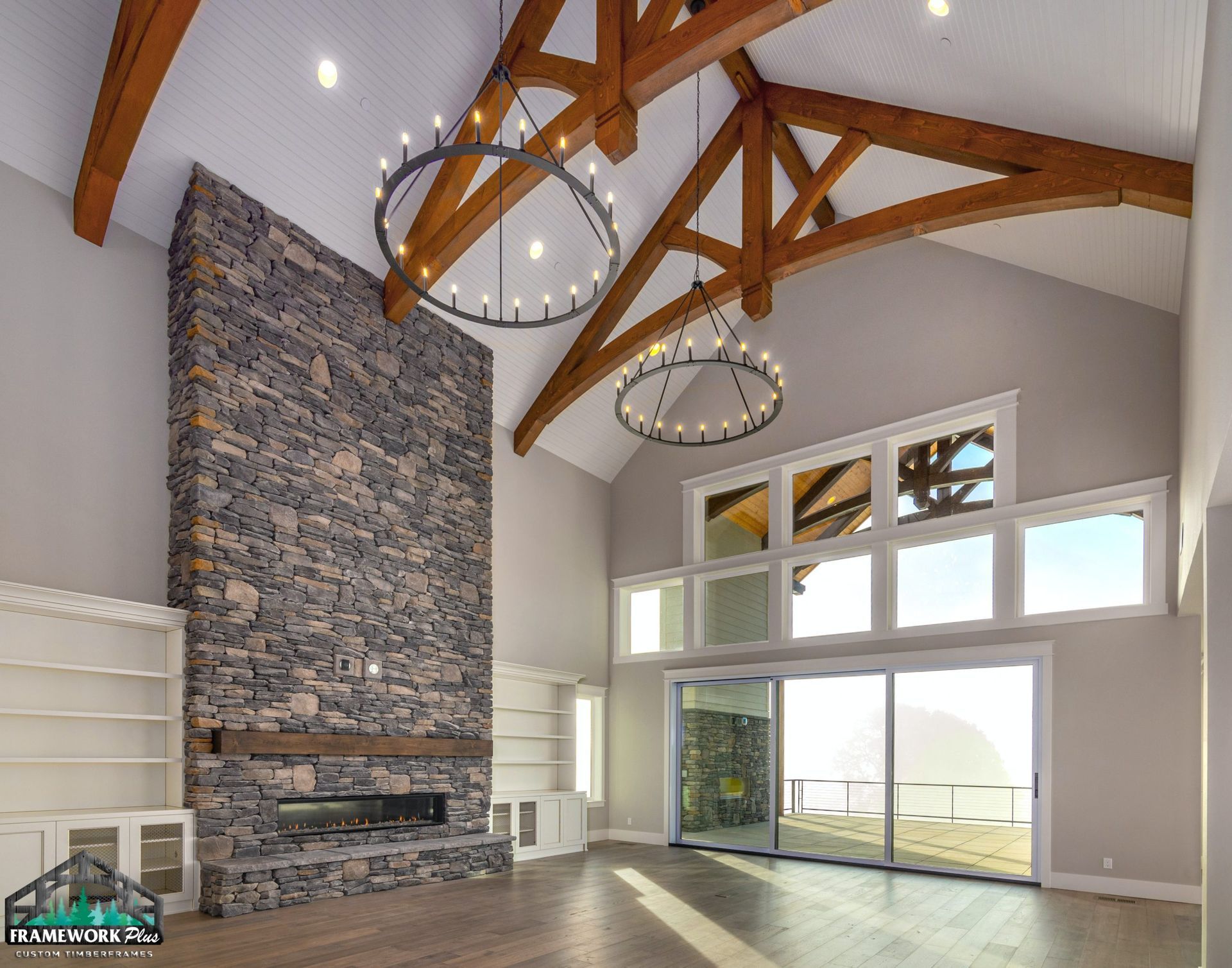 A living room with a large stone fireplace and wooden beams