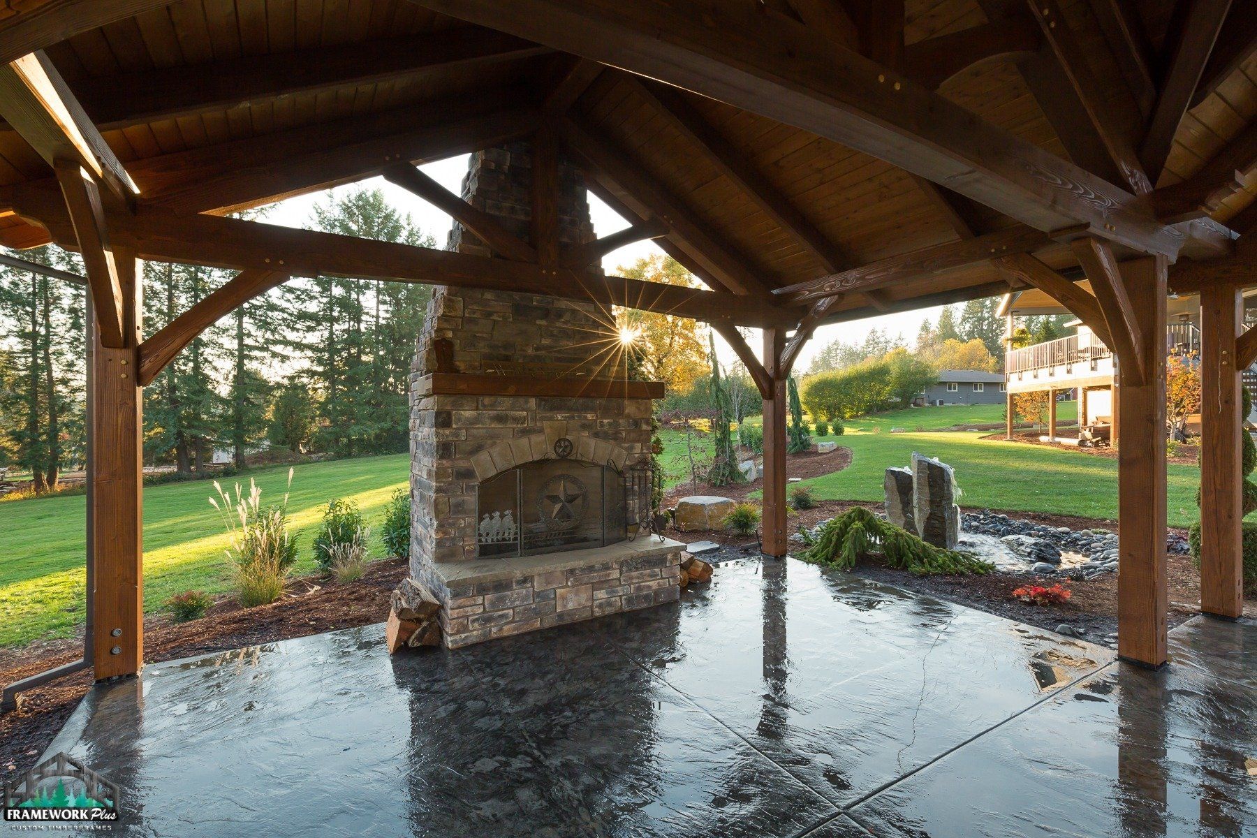 A large stone fireplace is under a wooden structure