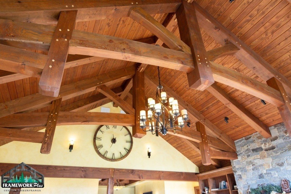 A wooden ceiling with a clock on the wall and a chandelier