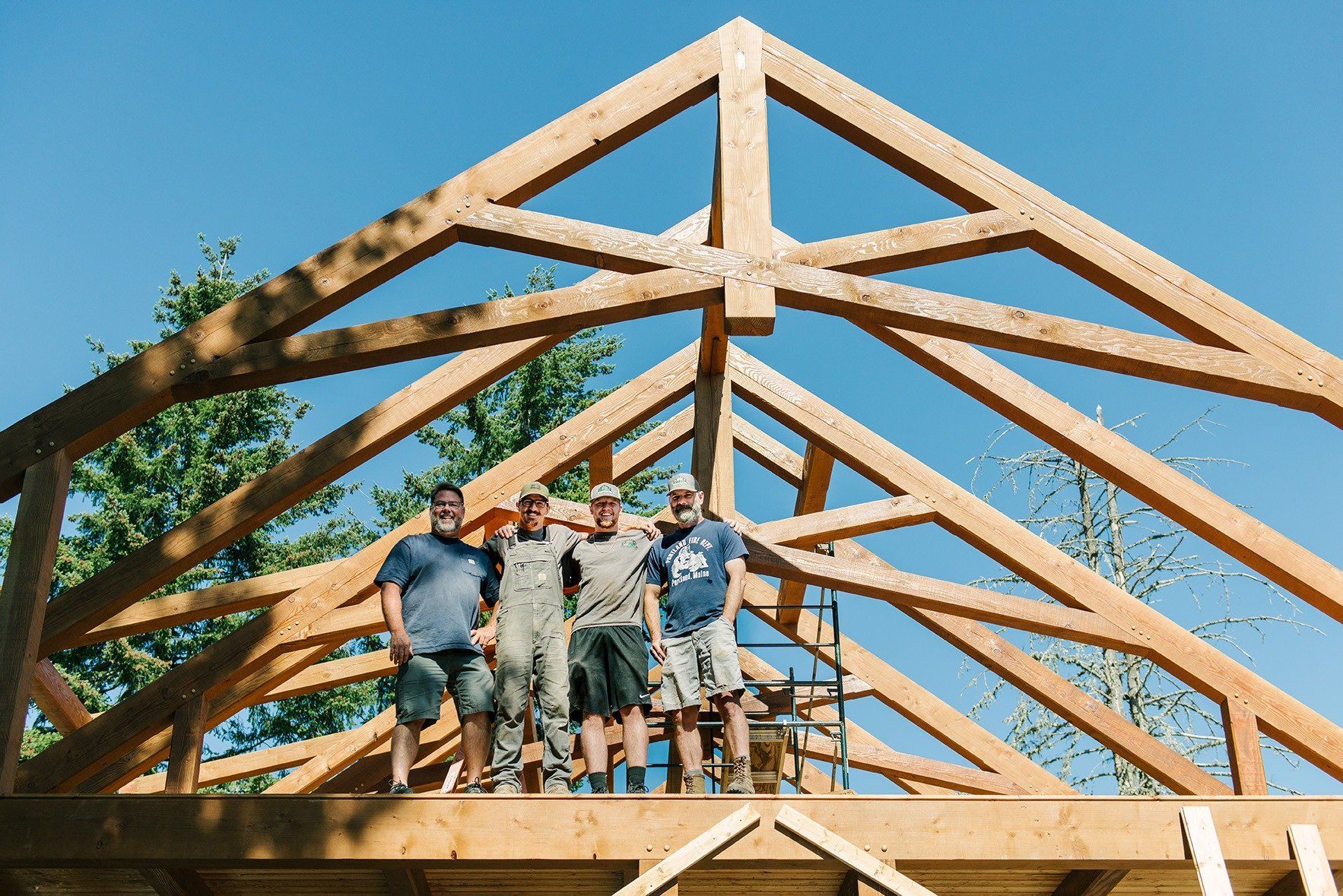 A group of men are standing on top of a wooden structure.